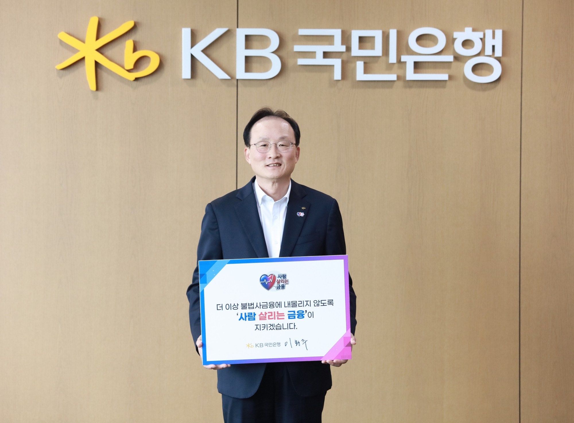 KB국민은행은 이환주 은행장이 ‘사람 살리는 금융 릴레이 캠페인’에 동참했다고 28일 밝혔다. 이환주 은행장이 ‘더 이상 불법사금융에 내몰리지 않도록 사람 살리는 금융이 지키겠습니다’라는 메시지가 적힌 피켓을 들고 기념 촬영을 하고 있다. ⓒKB국민은행